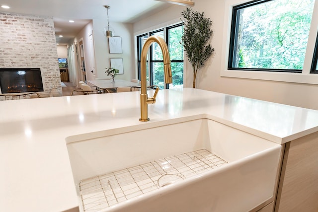 1008 Glades Rd, Gatlinburg, TN 37738 - kitchen view of a sink, a brick fireplace, decorative light fixtures, recessed lighting, and light countertops