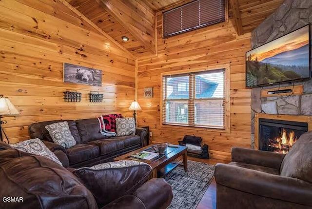 living room featuring wooden walls, a stone fireplace, and wooden ceiling