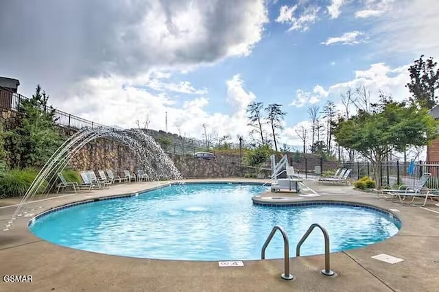 view of swimming pool featuring pool water feature and a patio