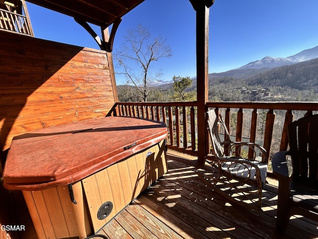 wooden deck with a mountain view and a hot tub