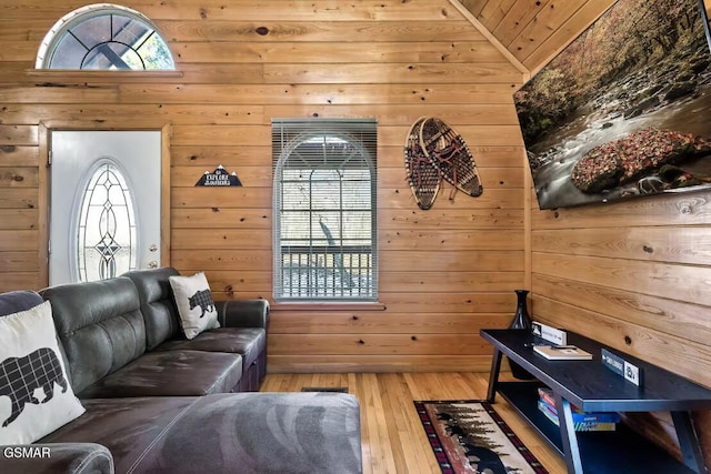 living room featuring vaulted ceiling, wood ceiling, and wood walls