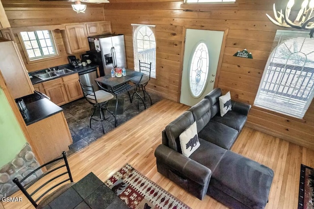 living room with wood walls, dark hardwood / wood-style flooring, sink, and an inviting chandelier