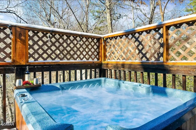 wooden deck featuring a hot tub