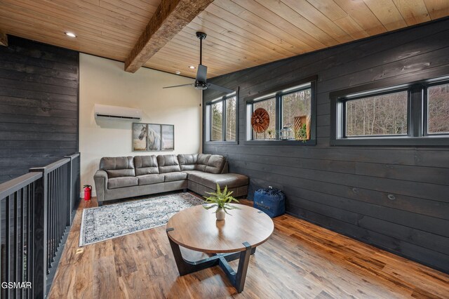 living area with wooden walls, a wall unit AC, wooden ceiling, beamed ceiling, and wood finished floors