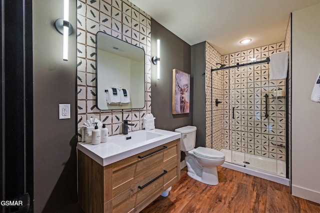 full bath with a stall shower, vanity, toilet, and wood finished floors