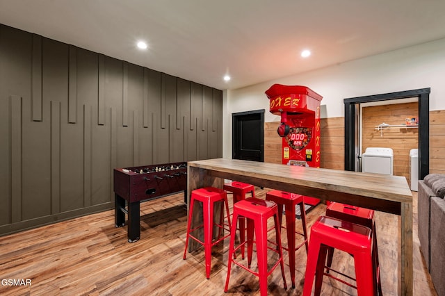 game room featuring recessed lighting, washing machine and clothes dryer, and wood finished floors