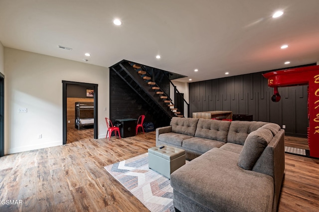 living area featuring recessed lighting, wood finished floors, visible vents, and stairs