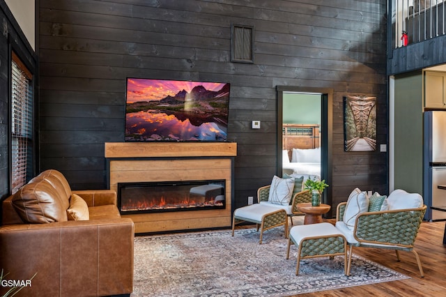 interior space featuring wood finished floors, a glass covered fireplace, visible vents, and wooden walls