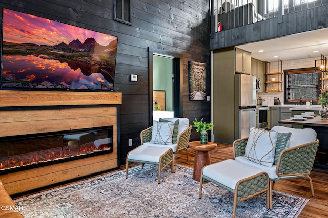 interior space featuring a glass covered fireplace, a healthy amount of sunlight, visible vents, and wood finished floors