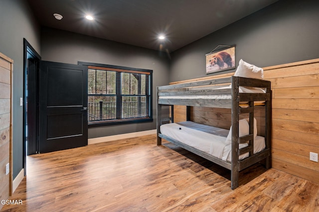 bedroom with baseboards, wood finished floors, and recessed lighting