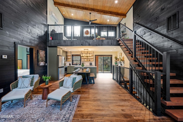 living room featuring wooden ceiling, wooden walls, wood finished floors, stairway, and beam ceiling