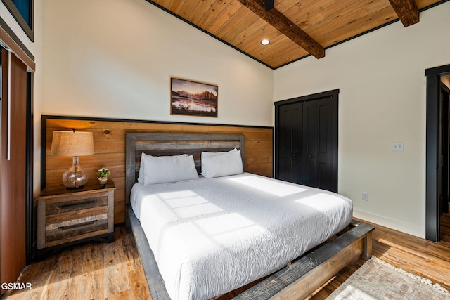 bedroom with vaulted ceiling with beams, recessed lighting, a closet, wood finished floors, and wooden ceiling