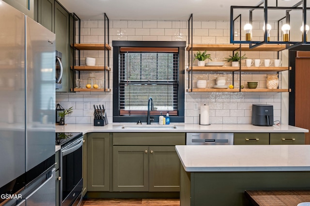 kitchen with green cabinetry, appliances with stainless steel finishes, open shelves, and a sink