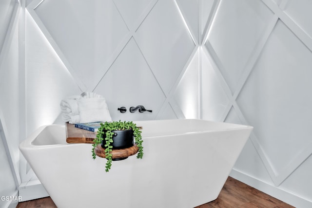 bathroom with hardwood / wood-style flooring and a tub to relax in