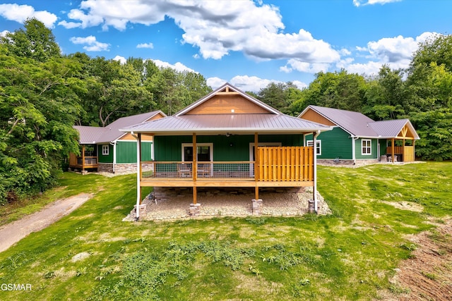 1012 Pinyon Cir, Pigeon Forge, TN 37863 - back of property with a metal roof, a lawn, board and batten siding, and a deck