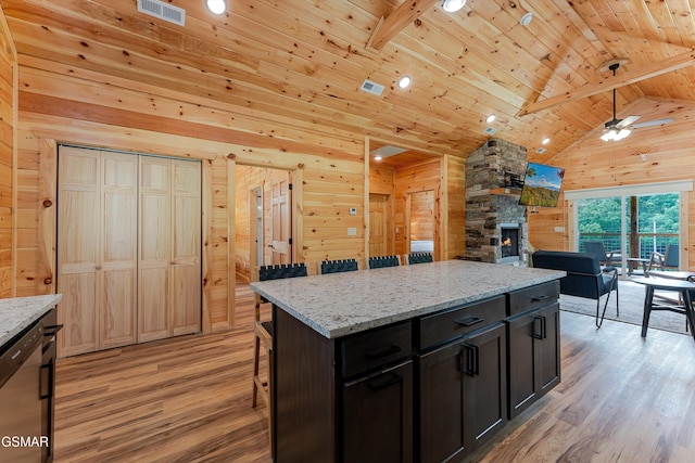 1012 Pinyon Cir, Pigeon Forge, TN 37863 - kitchen with wooden walls, light wood-type flooring, a stone fireplace, a wooden ceiling with exposed beams, and ceiling fan
