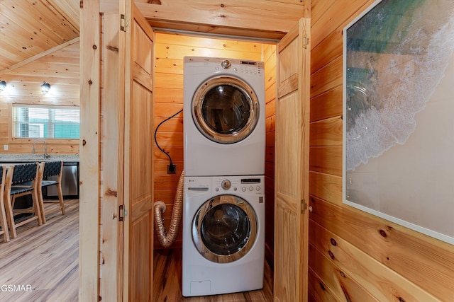1012 Pinyon Cir, Pigeon Forge, TN 37863 - laundry room with stacked washer and clothes dryer, wood ceiling, wooden walls, and light wood-type flooring