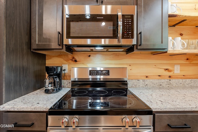 1012 Pinyon Cir, Pigeon Forge, TN 37863 - kitchen featuring stainless steel appliances, dark brown cabinetry, decorative backsplash, and light stone counters