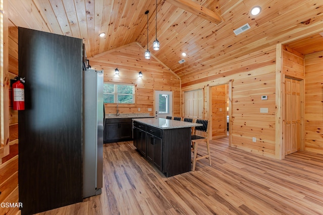 1012 Pinyon Cir, Pigeon Forge, TN 37863 - kitchen featuring a kitchen bar, wood ceiling, wood walls, light wood finished floors, and a center island