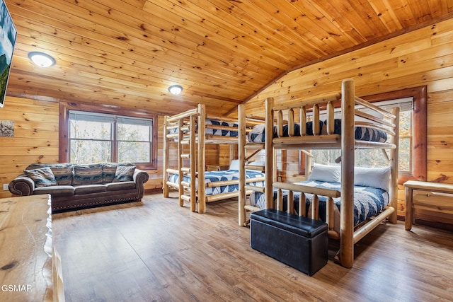 bedroom with lofted ceiling, wooden ceiling, wooden walls, and wood finished floors