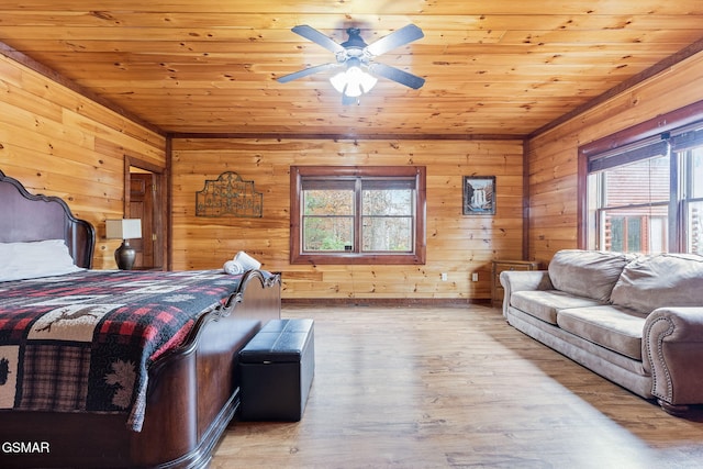 bedroom featuring light hardwood / wood-style floors, ceiling fan, wooden ceiling, and wood walls