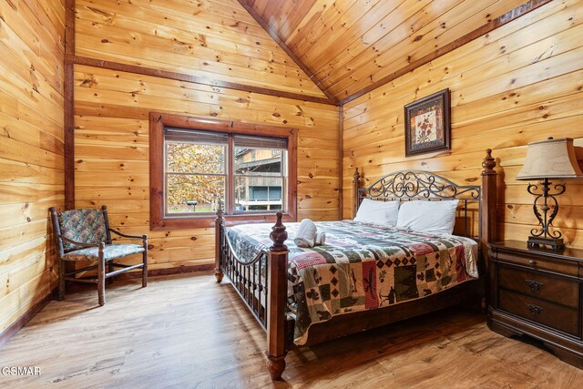 bedroom with lofted ceiling, wood ceiling, wooden walls, and wood finished floors