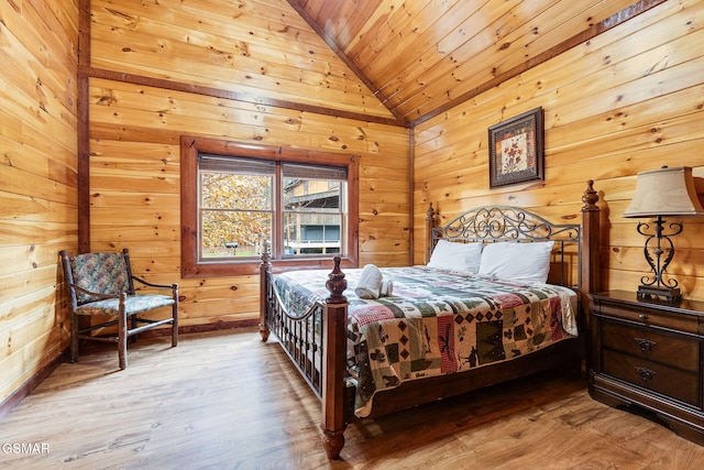 bedroom with lofted ceiling, wood ceiling, wood walls, and wood finished floors