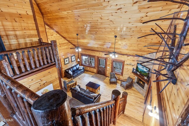 living room featuring wooden ceiling, wooden walls, high vaulted ceiling, and wood finished floors