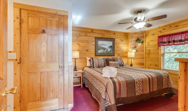 carpeted bedroom with ceiling fan and wood walls