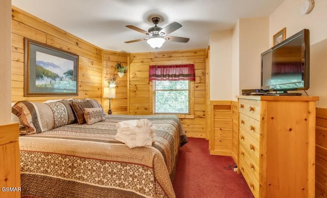 carpeted bedroom with wooden walls and ceiling fan