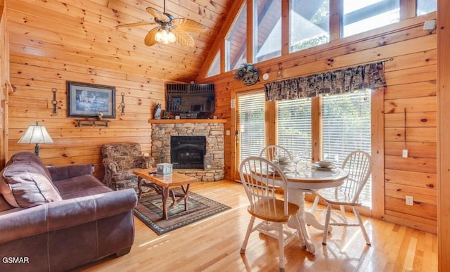 living room featuring beam ceiling, wood walls, and light wood-type flooring