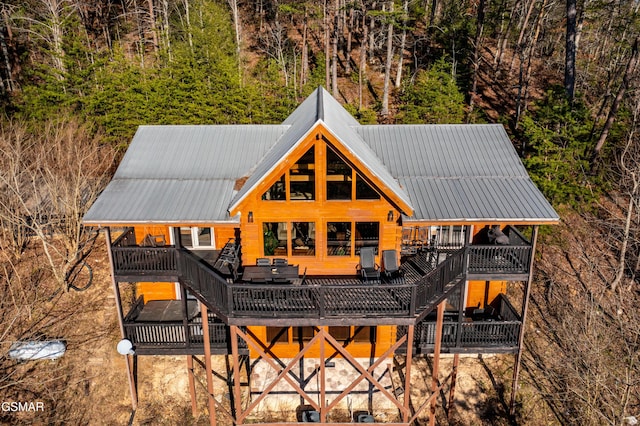 back of house with metal roof and a wooden deck