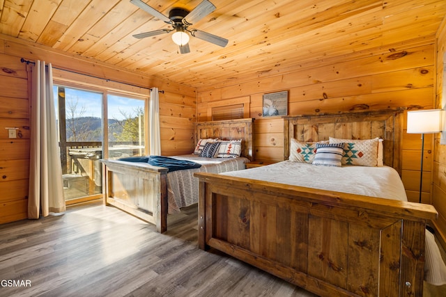 bedroom with access to exterior, ceiling fan, wooden walls, wood finished floors, and wooden ceiling