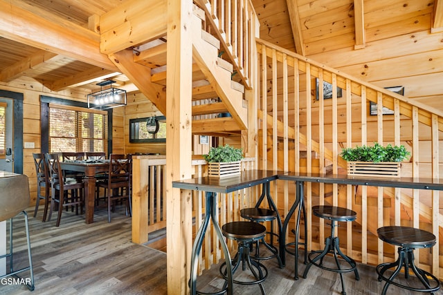 interior space with wooden ceiling, wood finished floors, beam ceiling, and wooden walls