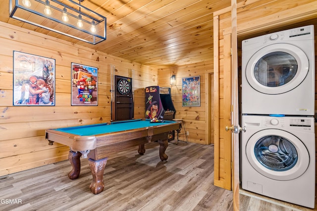 playroom with wooden walls, wood ceiling, wood finished floors, pool table, and stacked washing maching and dryer