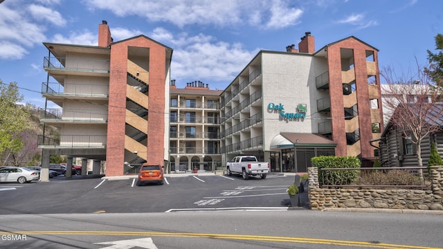 view of building exterior with covered and uncovered parking