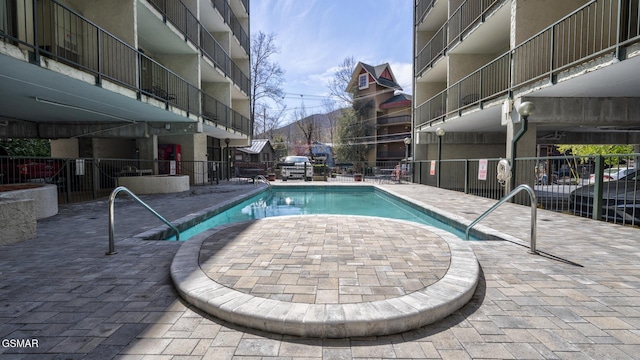 community pool with fence and a patio