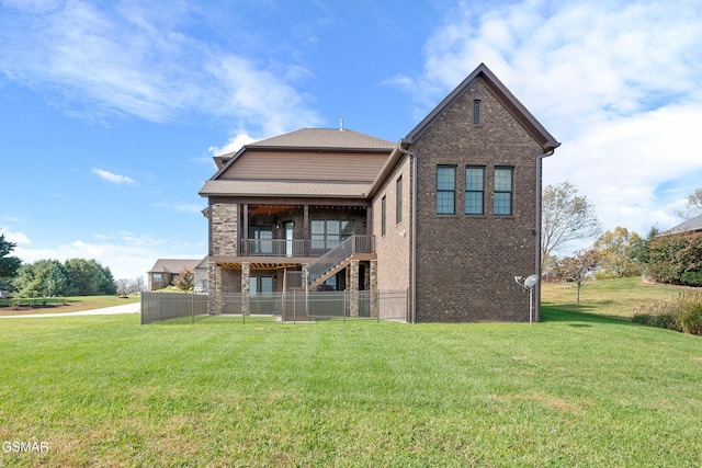 back of property with a yard and a balcony