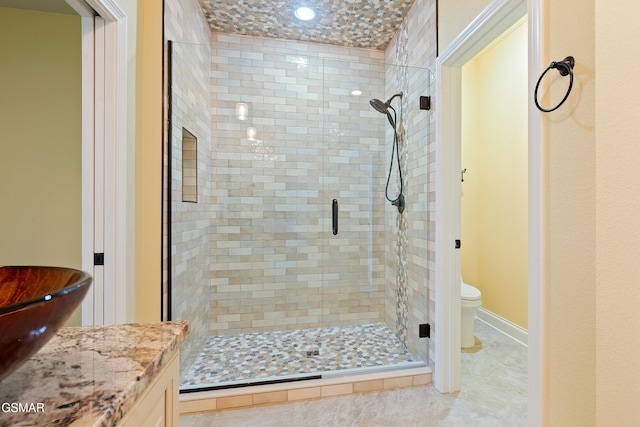 bathroom featuring tile patterned floors, vanity, toilet, and an enclosed shower