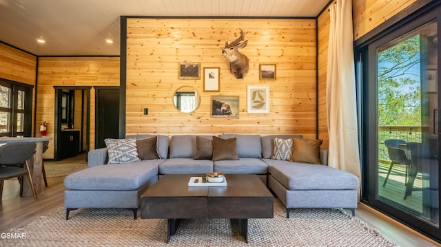 living area featuring wooden ceiling, wooden walls, wood finished floors, and a wealth of natural light