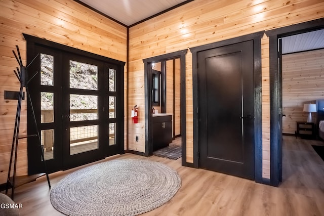 foyer entrance featuring wood walls and light wood-style floors