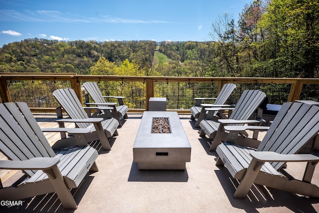 view of patio / terrace featuring a fire pit and a view of trees