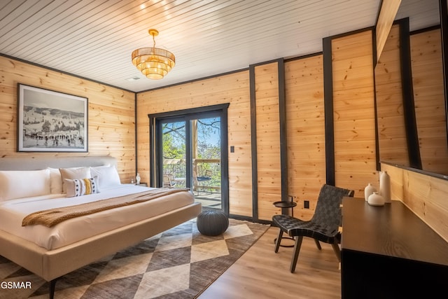 bedroom featuring wooden walls, wooden ceiling, wood finished floors, and access to outside