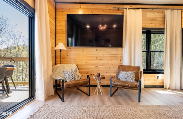 sitting room featuring wood finished floors and wood walls