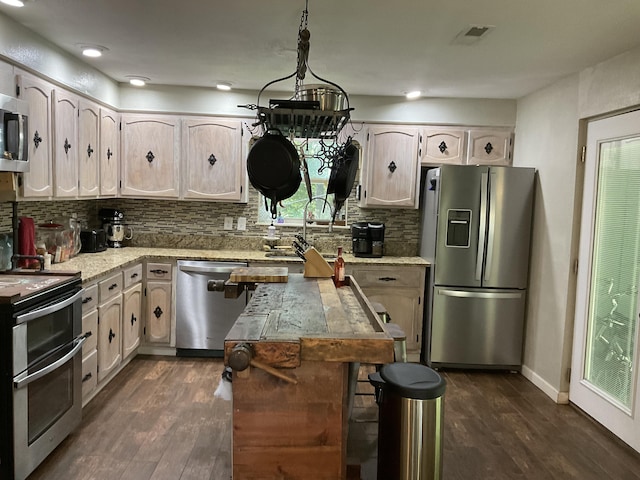 kitchen featuring decorative backsplash, appliances with stainless steel finishes, dark wood-type flooring, and pendant lighting