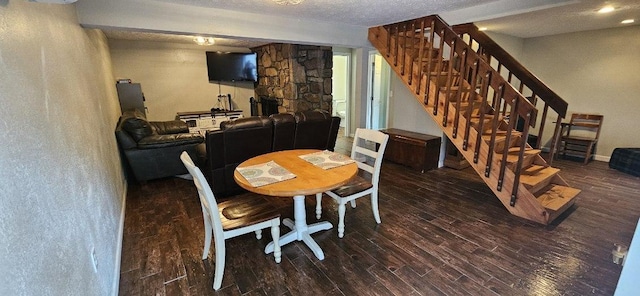 dining room with dark hardwood / wood-style floors and a textured ceiling