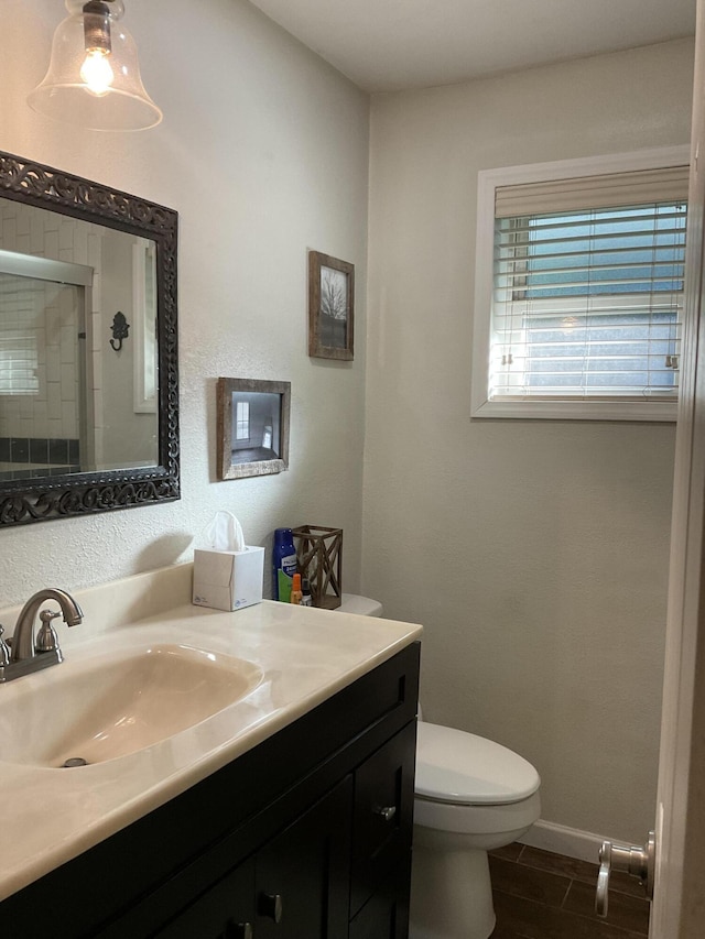 bathroom with a shower with door, vanity, and toilet