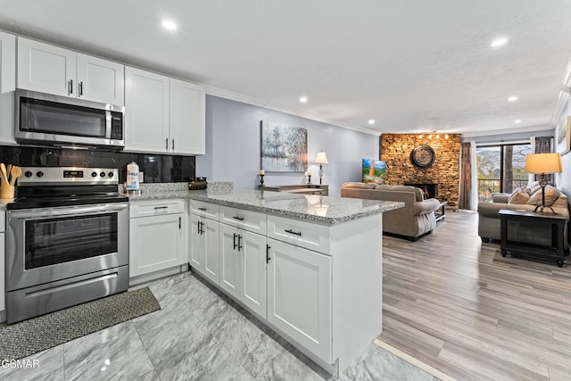 kitchen featuring white cabinetry, kitchen peninsula, and appliances with stainless steel finishes