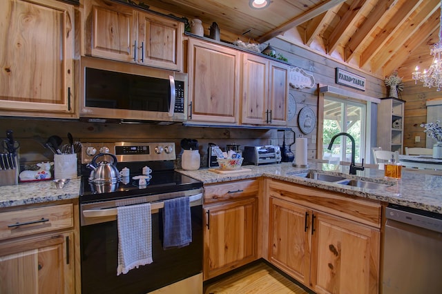 kitchen featuring sink, stainless steel appliances, wooden ceiling, light stone counters, and wooden walls