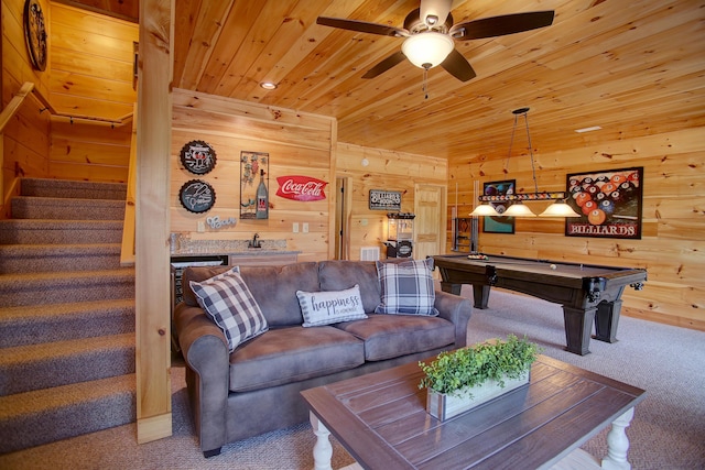 carpeted living room with ceiling fan, pool table, wooden ceiling, and wood walls